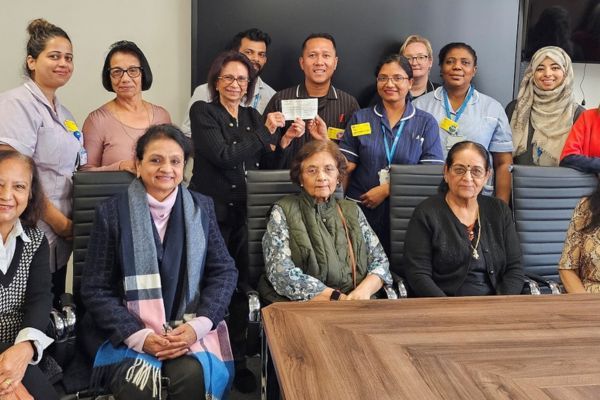 Photo of a group of people and staff sitting around a table