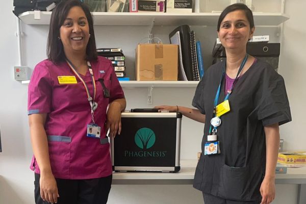 Sam and Waiza standing next to Phagenyx device in a case.