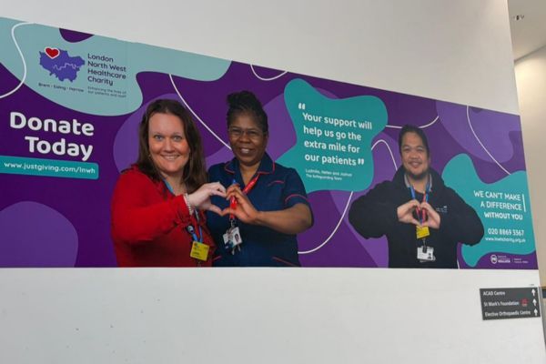 Three members of staff making heart shapes with their hands.