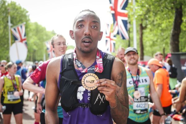 David proudly holding up his London Marathong medal.