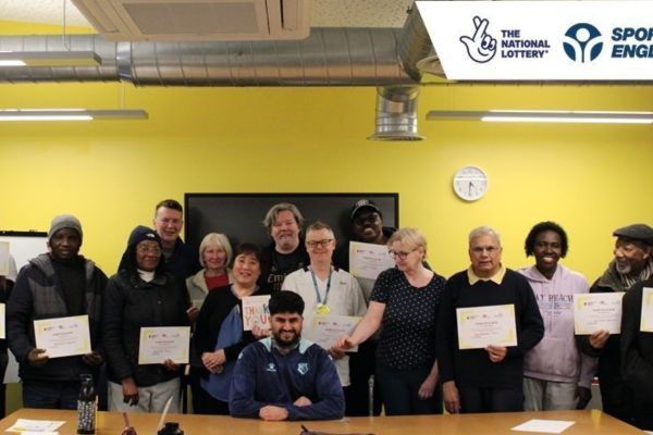 A group of people who took part in the programme holding up their certificates.