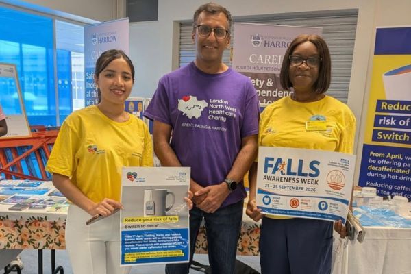 Two members of the falls team wearing yellow t-shirts and holding up falls awareness posters and Nadeem wearing a purple London North West Healthcare charity branded t-shirt.