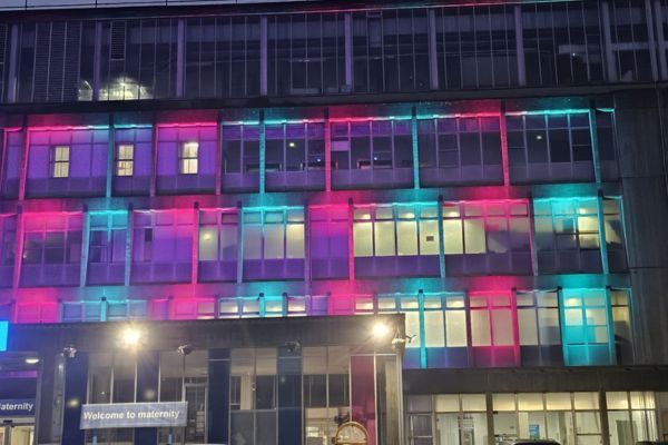 An image of the front of the maternity building at Northwick Park Hospital with pink and blue lights.